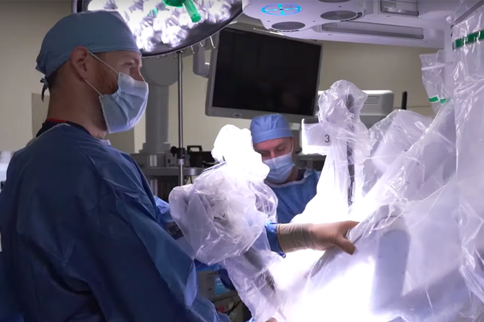 surgeon-adjusting-davinci-robot