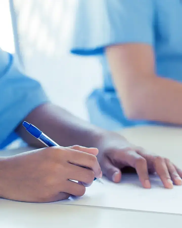 two nurses writing on a piece of paper