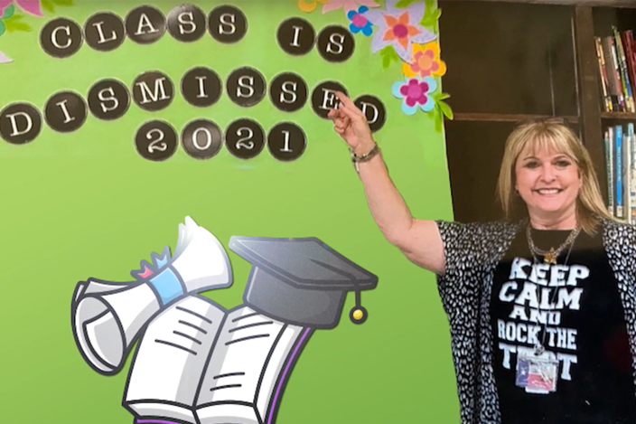 female-teacher-pointing-at-bulletin-board