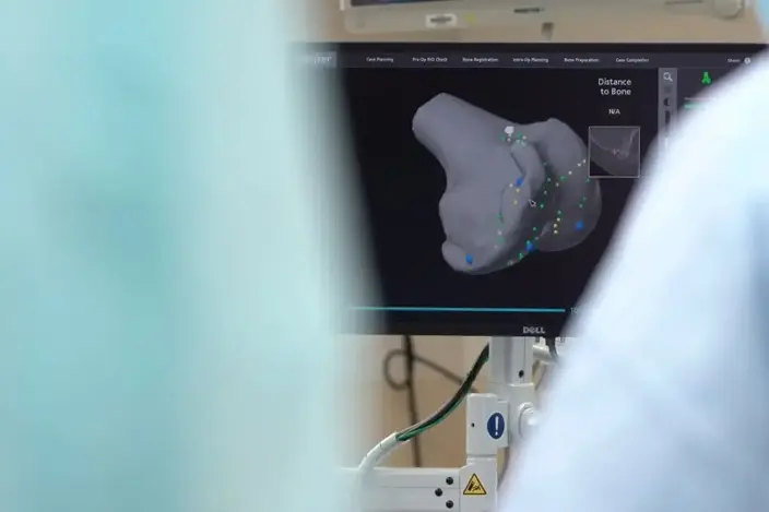 a man in a hospital room looking at a monitor